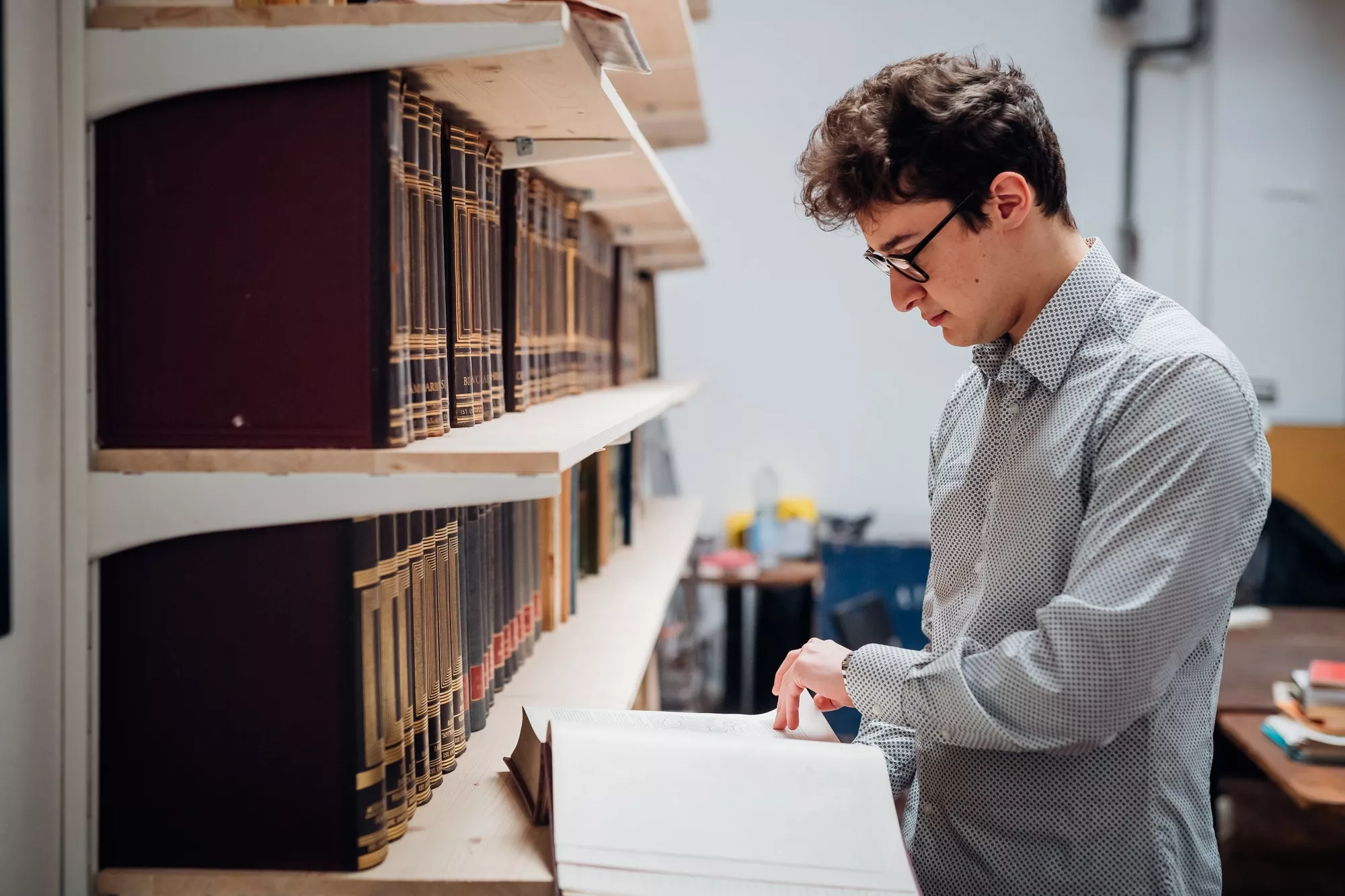 Young caucasian man indoor library reading book