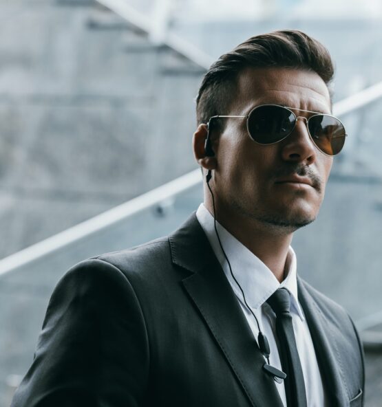 handsome security guard standing in sunglasses with security earpiece